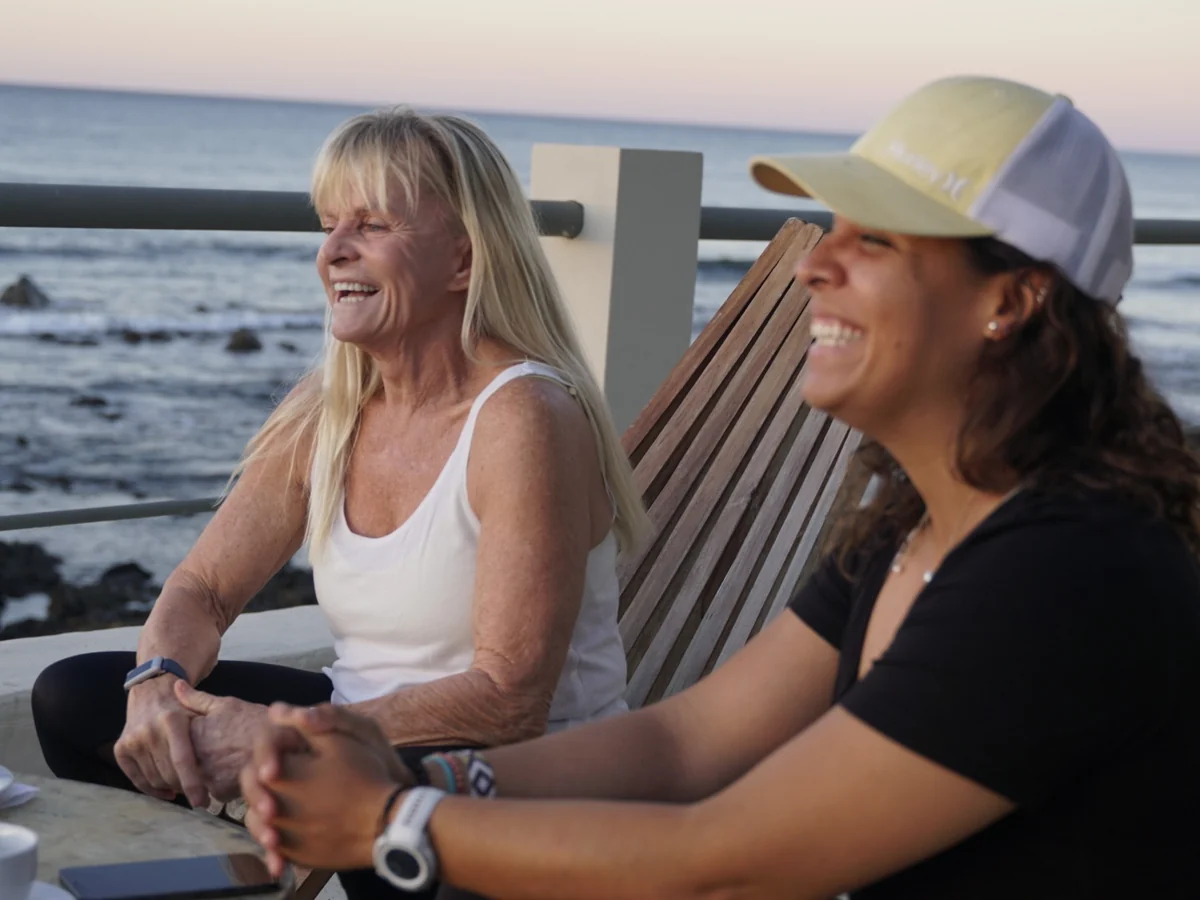 Joss Alabi and a returning guest talking by the ocean during a one to one session